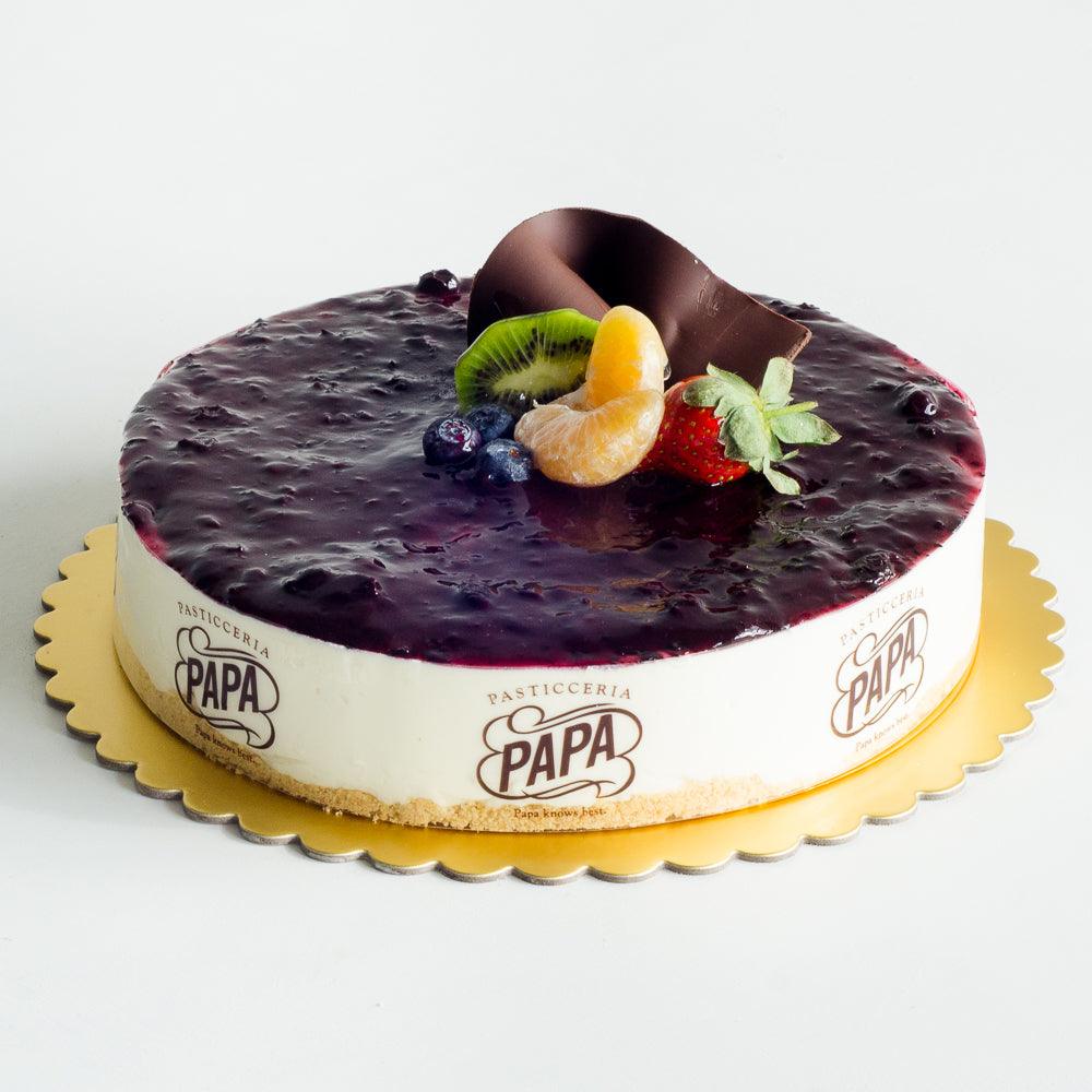Pasticceria Papas Bluberry Cheese Cake decorated with chocolate swirl and fruit