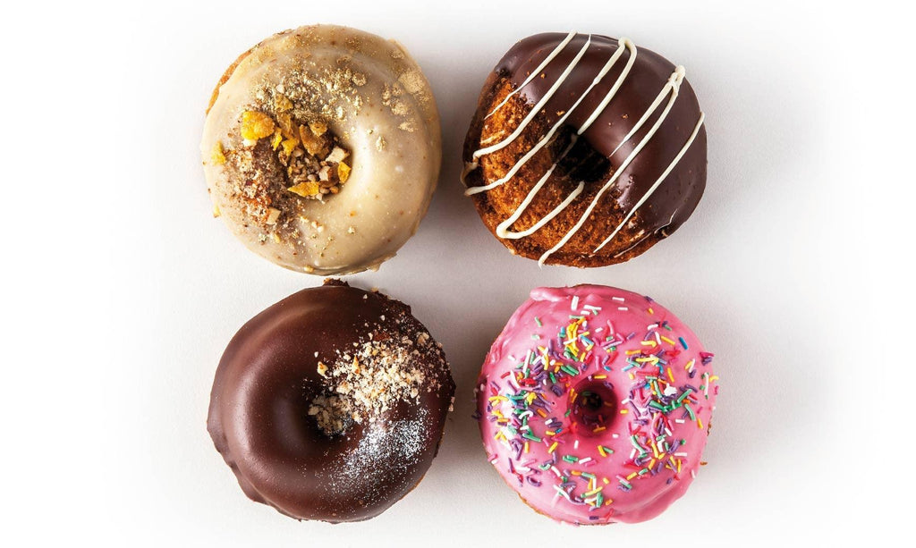 Organic Vegan Donuts with flavours including Berry Sprinkles, Cinnamon Churro, Chocolate Hazelnut and Maple Crunch in a box of 4