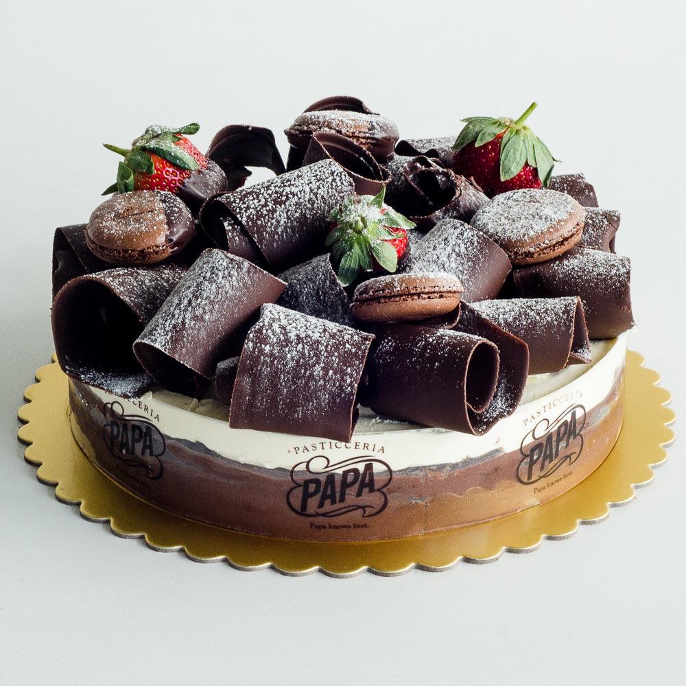 Pasticceria Papa's Black Forest Cake topped with chocolate swirls, macarons and strawberries
