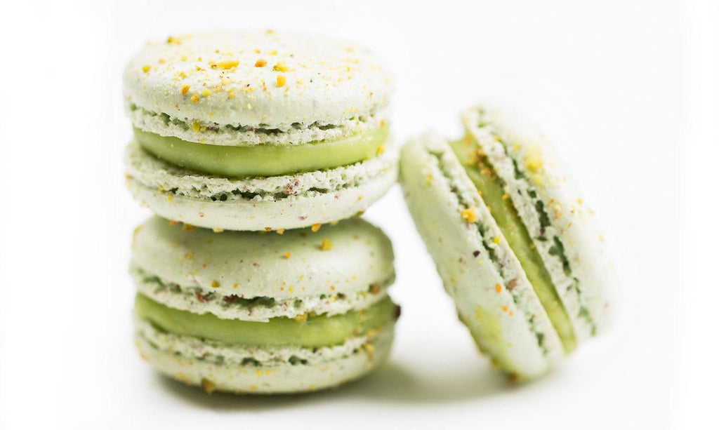 Pistachio Praline Macarons made by Two tiny mounds of almond meringue sandwiched, between sweet pistachio buttercream in 12 pack